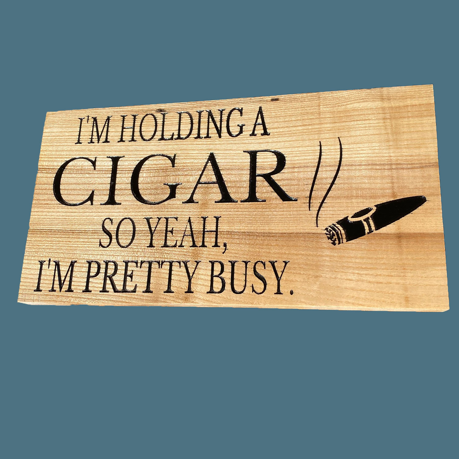 Wooden sign with an engraved cigar and saying I'm holding a cigar so yeah I'm pretty busy